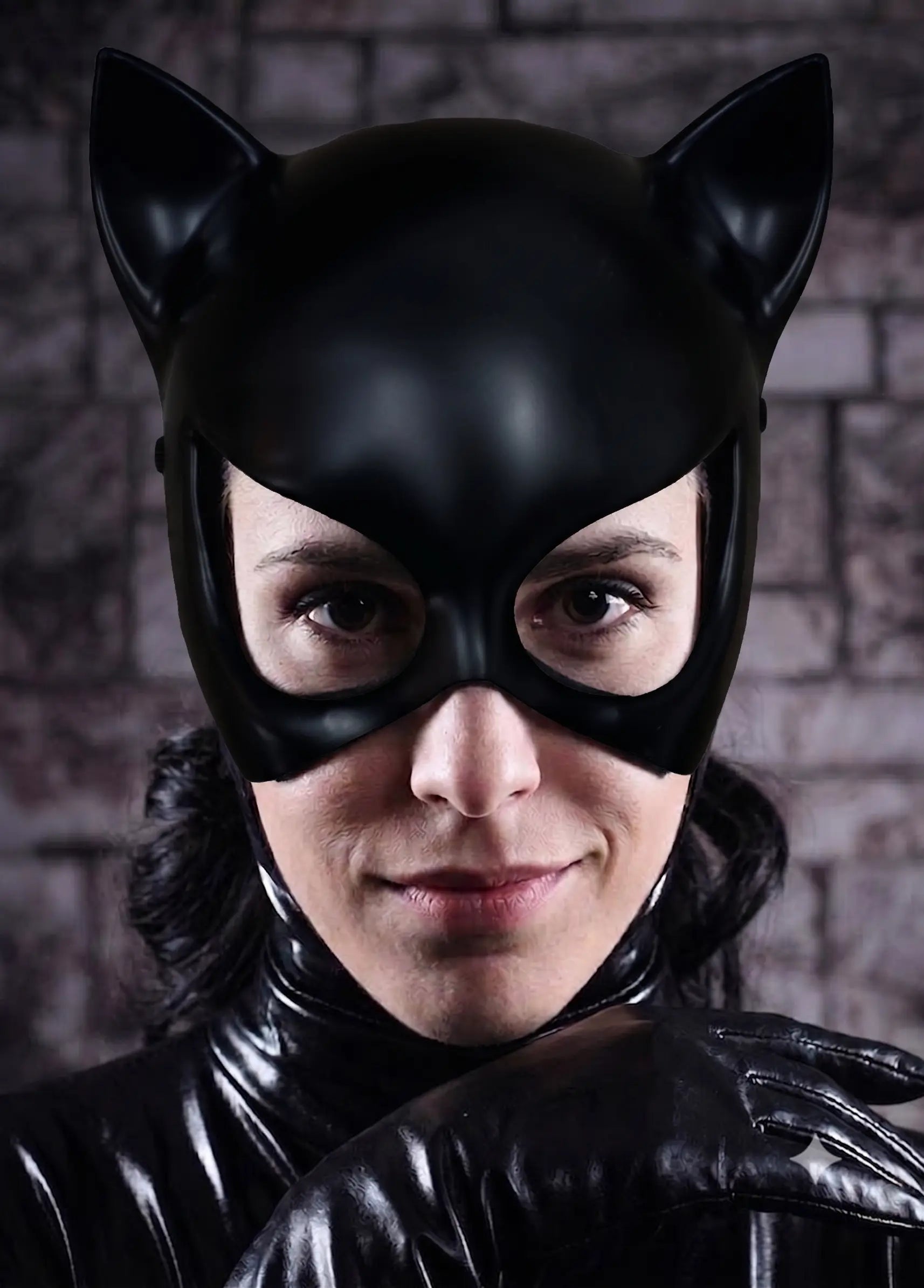 Person wearing a black cat-themed costume with a mask against a brick wall for halloween cosplay