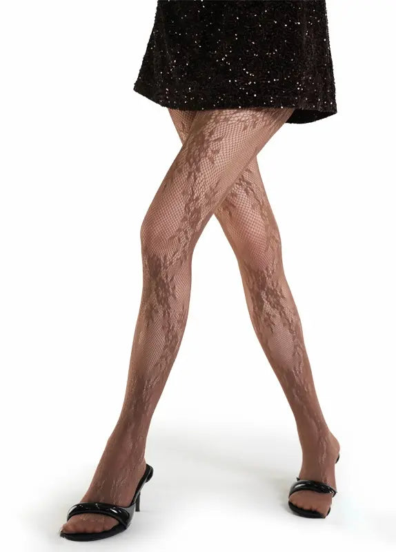 Fishnet stockings worn with a black dress on a white background