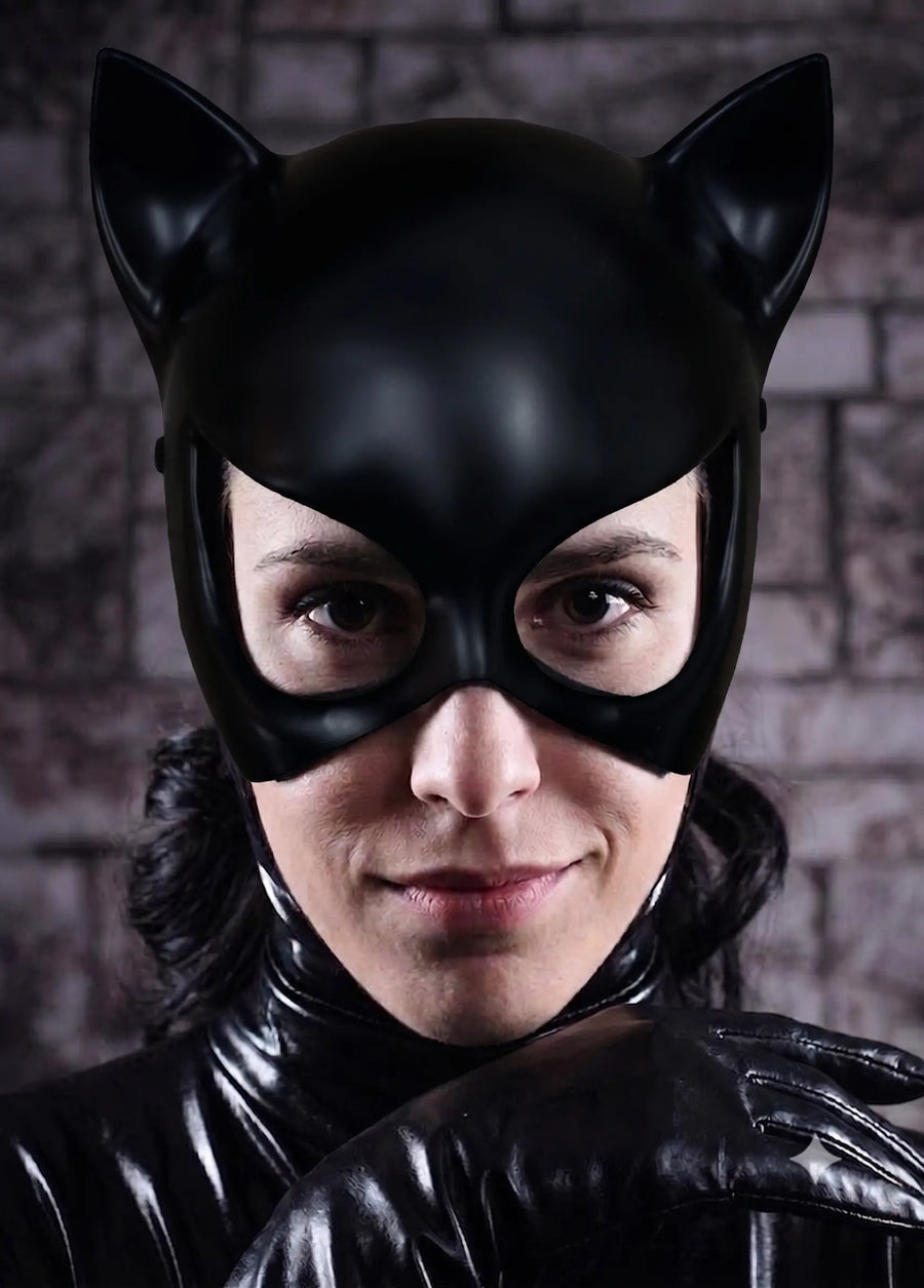 Person wearing a black cat-themed costume with a mask against a brick wall for halloween cosplay